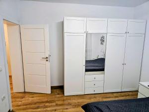 a bedroom with white cabinets and a bed at Ana Residence in Timişoara +16 photos