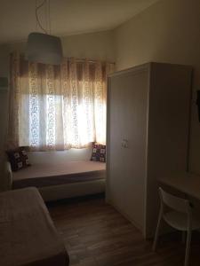 a bedroom with a bed and a window with curtains at Villa Amico B&B San Leone in Agrigento