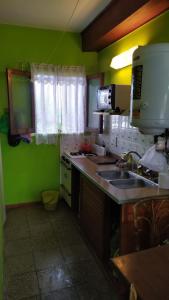 cocina con paredes verdes, fregadero y microondas en depto San Bernardo, en San Bernardo