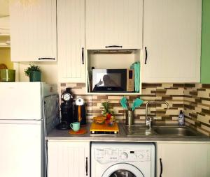 a kitchen counter with a microwave and a dishwasher at Olina - Proche plage, balcon, wifi, parking, calme in Les Sables-dʼOlonne