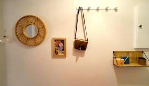 a mirror and a picture hanging on a wall at Olina - Proche plage, balcon, wifi, parking, calme in Les Sables-dʼOlonne