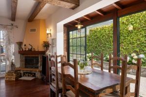 a dining room with a wooden table and a large window at Casa da Avo in Faial