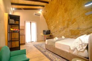 a bedroom with a bed and a chair in a room at Villa Cavetta in Agrigento