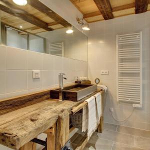 a bathroom with a wooden sink and a mirror at L'Ours Blanc Lodge in Le Biot