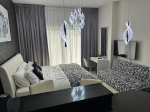 ein Hotelzimmer mit einem Bett und einer Couch in der Unterkunft Big studio, Dubai SportCity, parking included in Dubai + 42 Fotos