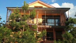a house with palm trees in front of it at Villa Sosnovy Bor in Zatoka