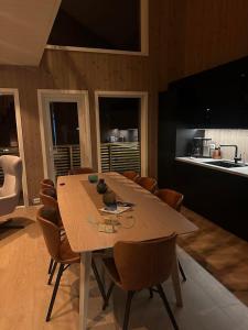 a dining room with a wooden table and chairs at Finnvika Panorama, Stamsund - Lofoten in Stamsund +4 photos