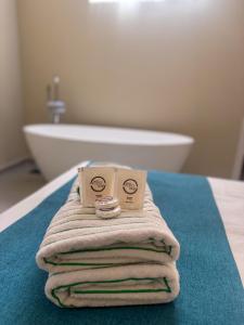 a pile of towels sitting on a bed with a bath tub at Pousada Estalagem do Porto in Arraial do Cabo