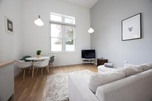 Una sala de estar blanca con un sofá blanco y una mesa. en The Avenue, en Leamington Spa
