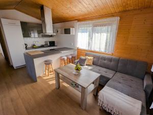 a living room with a couch and a table and a kitchen at Sedmikvítek in Smržovka