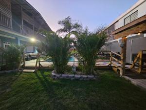a yard with palm trees and a building at Pelican Dock Apartments in Aguada