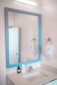 a bathroom with a large mirror above a sink at Sunset Family Package Units 304 & 305 in Jacó