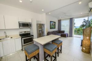 a kitchen and living room with a table and chairs at Sunset Family Package Units 304 & 305 in Jacó