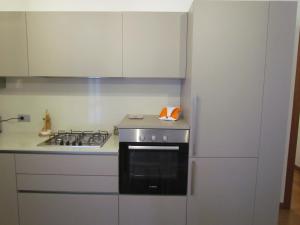 cocina con fogones y armarios blancos en Residenza Zaira, en Preganziol