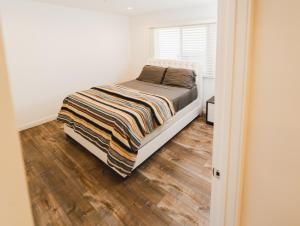a bedroom with a bed and a wooden floor at Modern 1 Bedroom Apartment Near Hollywood and Koreatown Free Gated Parking Full Kitchen in Los Angeles
