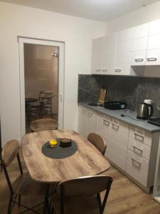 a kitchen with a wooden table with chairs and a tableasteryasteryasteryasteryastery at Paradise in Vukovar