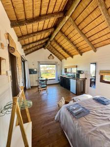 a large room with a bed and a kitchen at Complejo Las Carmelas in Punta Del Diablo