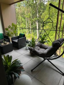 a chair sitting on a balcony with a view of trees at Apartament Virgo in Międzyzdroje
