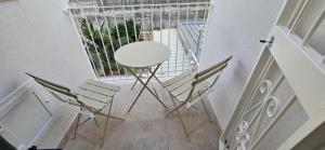 a room with chairs and a table and a window at Bellini Holiday House in Mola di Bari