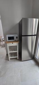a kitchen with a stainless steel refrigerator and a microwave at Bellini Holiday House in Mola di Bari