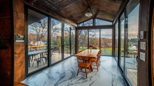 a dining room with a table and chairs and windows at Muskoka Lakeview Cottage - Pier 100 #40 in Port Carling