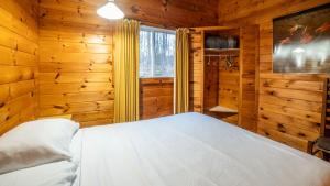 a bedroom with a bed in a log cabin at Muskoka Lakeview Cottage - Pier 100 #40 in Port Carling