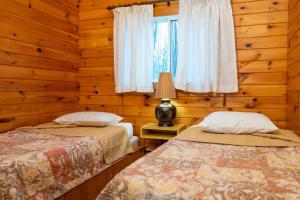 two beds in a log cabin with a window at Muskoka Lakeview Cottage - Pier 100 #40 in Port Carling +16 photos