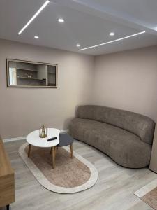 a living room with a couch and a table at 3 Min To Center Stylish Stay's in Tirana