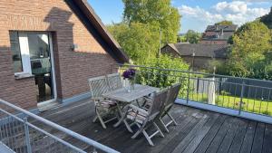 une terrasse en bois avec une table et des chaises dessus dans l'établissement Apartment Köln Bonn DeLux Burgblick, à Bornheim