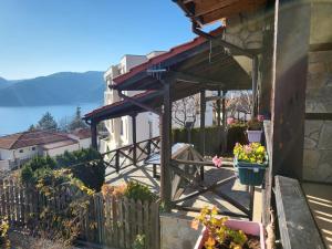 a house with a balcony with flowers on it at Penev guest house in Glavatartsi