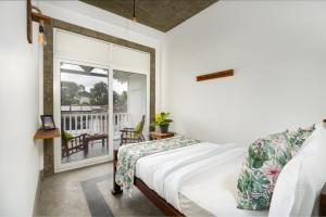 a bedroom with a bed and a balcony at COLOMBO Eco Lodge & Wellness Centre in Colombo