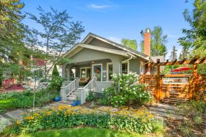 une petite maison avec une terrasse couverte et une clôture dans l'établissement Maple Courtyard - Old Town with King Suite & Piano, à Fort Collins