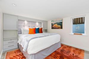 - une chambre dotée d'un grand lit avec des oreillers orange et bleu dans l'établissement Maple Courtyard - Old Town with King Suite & Piano, à Fort Collins