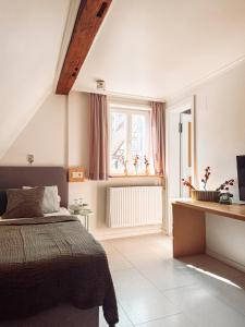 a bedroom with a bed and a television in it at Hotel Restaurant Ratsstube in Calw