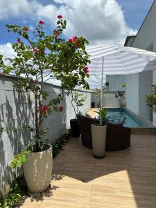 a patio with potted plants and a swimming pool at Nosso lar na COP in Marituba