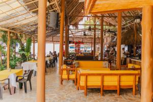 a restaurant with tables and chairs and people in the background at Hotel Isla Real in Tierra Bomba