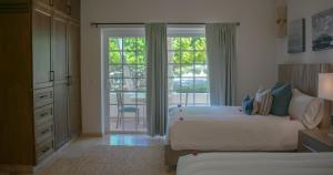 Un dormitorio con dos camas y una puerta corrediza de cristal. en Los Cabos Golf Resort, Trademark Collection by Wyndham, en Cabo San Lucas 121 fotos más