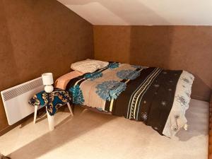 a small bedroom with a bed and a table at Maison de village in Poncin