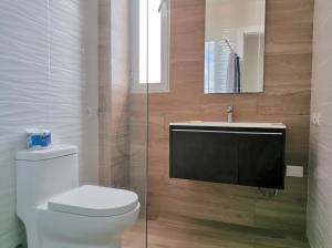 a bathroom with a toilet and a sink and a mirror at Cozy suite with pool access in Punta Cana