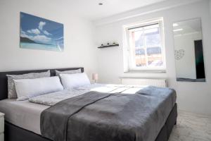 a bedroom with a large bed and a window at Dachgeschosswohnung mit Klimaanlage-15min vom Europa Park entfernt in Kenzingen +62 photos