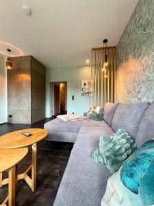 ein Wohnzimmer mit Sofa und Tisch in der Unterkunft Deluxe Apartment mit Balkon und Frühstück im Hotel Reindahls in Wilkendorf