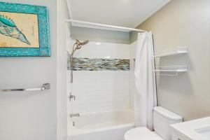 Un baño blanco con inodoro y ducha. en Sea Cabin 227-B, en Isle of Palms 10 fotos más