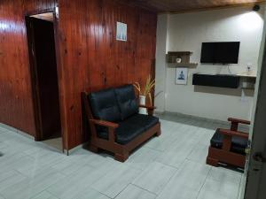 a living room with a chair and a television at Lo de Toty 2 in Yapeyú