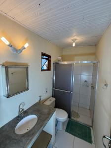 a bathroom with a toilet and a sink and a shower at Pousada Loquinhas in Alto Paraíso de Goiás +58 photos