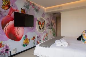 a bedroom with a wall with a butterfly mural at Street Art Hotel Roma in Mexico City