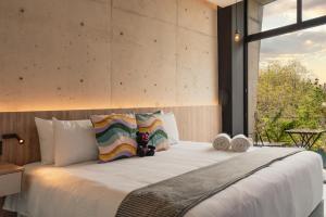 a bedroom with a large bed with a large window at Street Art Hotel Roma in Mexico City