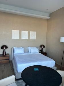 a bedroom with a large bed and a table at Baku Seabreeze White Residences seaview, studio apartment in Baku