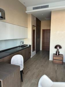 a kitchen with white chairs and a table and a counter at Baku Seabreeze White Residences seaview, studio apartment in Baku +3 photos