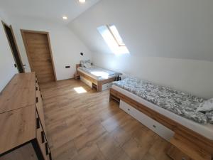 een kamer met twee bedden en een houten vloer bij Riverside Apartma 2, Kranjska Gora in Kranjska Gora