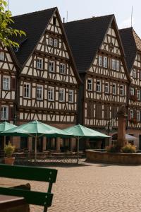 a building with green umbrellas in front of it at Hotel Restaurant Ratsstube in Calw
